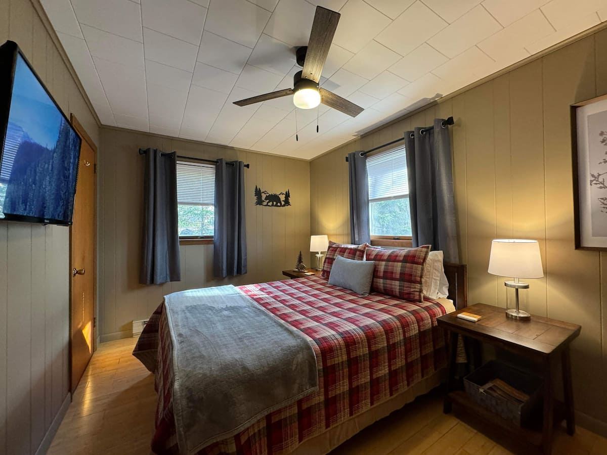 Bedroom with a queen bed and plaid bedding