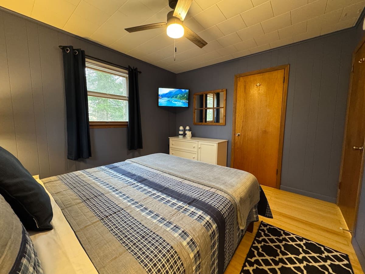 Third bedroom with a queen bed and a wall-mounted TV